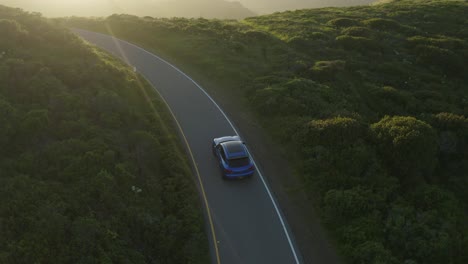 Porsche-Macan-driving-through-the-golden-hills-in-the-Marin-Headlands,-San-Fransisco,-at-sunset