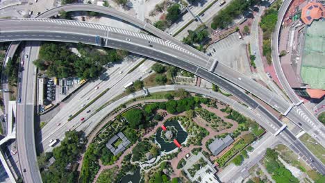 Top-down-aerial-view-traffic-on-multiple-Highway-roads-with-the-Pavilion-of-Absolute-Perfection-and-Nan-Liana's-garden-in-the-heart-of-Hong-Kong