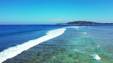 Antena-De-Olas-Poco-Profundas-Rompiendo-En-Un-Hermoso-Arrecife-De-Coral-Frente-A-La-Costa-De-Una-Hermosa-Isla-De-Playa