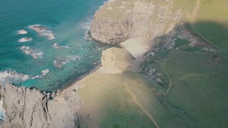 Cinematic-aerial-drone-video-of-splashing-ocean-waves-into-a-scenic-mountains-of-Sabtang,-Batanes-in-the-Philippines