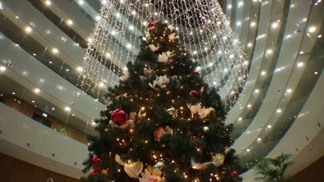 Hanging-Garlands-Revolve-Around-Christmas-Tree-In-Modern-Building