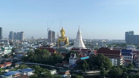 Big-Golden-Buddha-sitting-in-a-city-landscape,-Wat-Paknam-under-construction