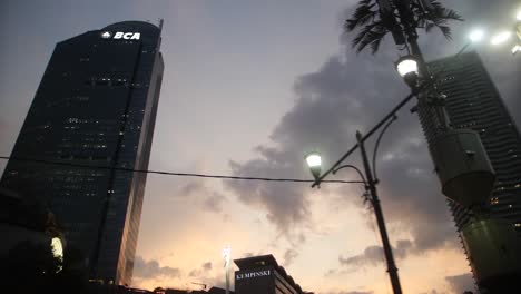 Slow-motion-shot-of-skyscrapers-against-the-colorful-sky-in-Jakarta,-Indonesia-during-sunset