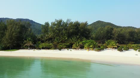 Idyllic-holiday-destination-with-secluded-white-sand-surrounded-by-palm-trees-and-calm-clear-sea-in-Malibu-beach,-Koh-phangan,-Thailand