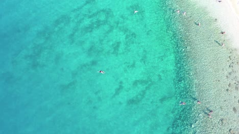 People-swimming-in-the-sea,-crystal-clear-water