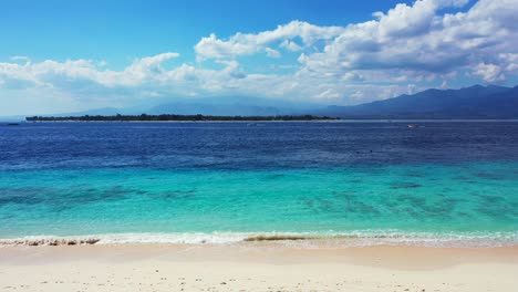 Idyllischer-Exotischer-Strand-Mit-Weißem-Sand,-Der-Von-Kristallklarem-Smaragdwasser-Aus-Blauem-Türkisfarbenem-Meer-An-Einem-Hellen-Himmel-Mit-Wolkenhintergrund-In-Bali-Gewaschen-Wird