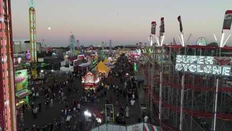 Aerial-View-of-Florida-State-Fair-During-Sunset-With-Rollercoaster-and-People-Walking-Around