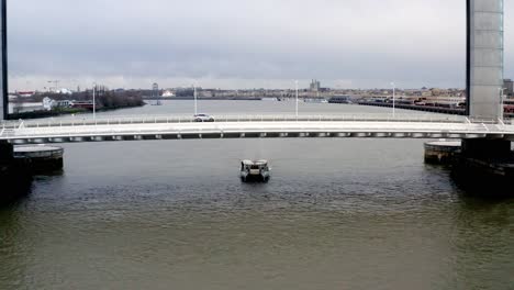 Jacques-Chaban-Delmas-Brücke-In-Bordeaux,-Frankreich,-Mit-Autoverkehr-Und-Einem-Darunter-Vorbeifahrenden-Boot-Auf-Dem-Fluss-Garonne,-Luftaufnahmen-Aus-Der-Luft