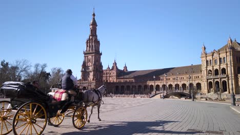 Touristen-Fahren-In-Der-Pferdekutsche-Auf-Der-Plaza-De-Espana,-Sevilla,-Spanien,-Slowmo