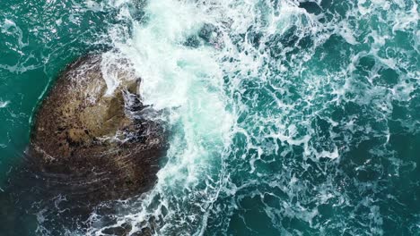 Foamy-waves-washing-the-big-stone-in-the-emerald-ocean
