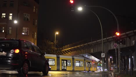 Urban-Street-Scene-at-Night-in-Rainy-Berlin-with-Tram-and-Metro-Train