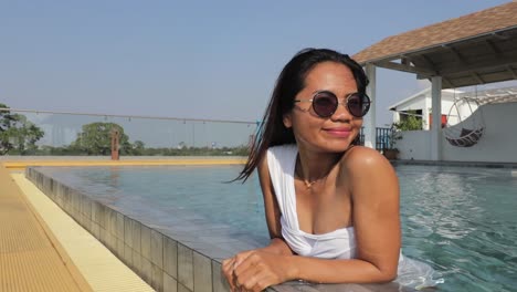 Eine-Hübsche-Frau-Im-Weißen-Badeanzug,-Die-Sich-Im-Sommer-Im-Pattaya-Hotel-Am-Pool-Entspannt---Nahaufnahme