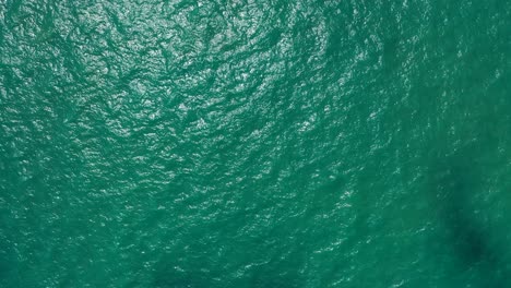 Schöner-Abstrakter-Smaragdgrüner-Meerwasserhintergrund-Mit-Der-Sonne,-Die-Auf-Der-Wasseroberfläche-Reflektiert-Wird