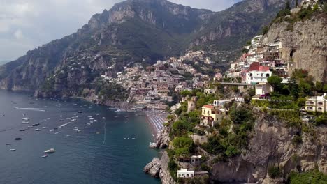 Positano-in-the-Italian-Amalfi-coast-seen-from-the-side-showing-colorful-hillside-mansions,-Aerial-left-pan-reveal-shot