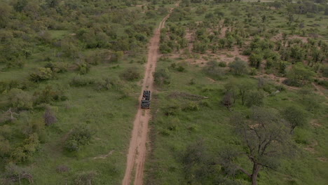 Imágenes-Aéreas-De-Un-Vehículo-De-Safari-Conduciendo-Por-Un-Camino-De-Tierra-En-Sudáfrica