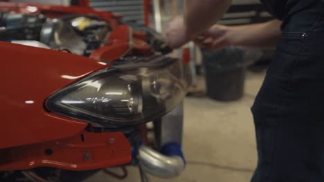 Tight-Shot-of-a-Man-Installing-a-Headlight-on-a-Red-Nissan-Silvia