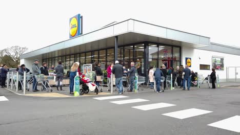 Queues-of-'panic-buyers-outside-supermarket,-Lidl-during-the-Coronavirus-outbreak-in-England,-UK