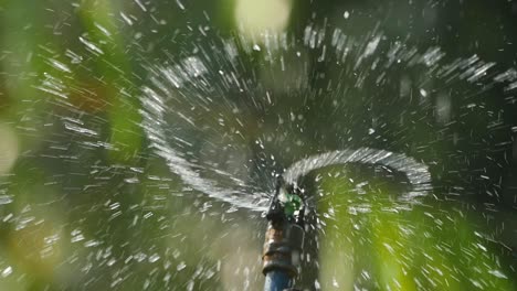 Ein-Sprinkler-Versprüht-Wasser,-Um-Die-Umgebung-Im-Sommer-Zu-Bewässern,-Da-Es-Die-Hitze-Der-Sonne-In-Indien-Abkühlt