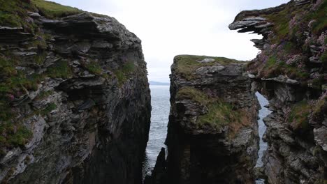 Tilt-down-push-forward-drone-shot-of-ocean-cliffs