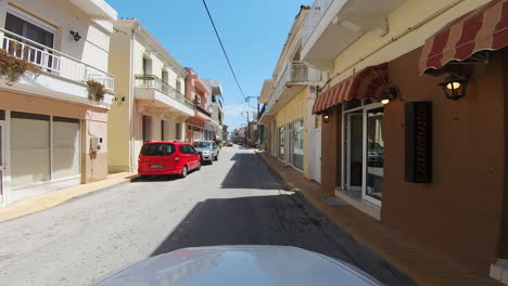 Driver-POV-passing-through-a-Greek-village-central-road