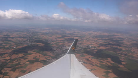 Aerial-shot-of-airplane-wing-flying-through-clouds,-Europe