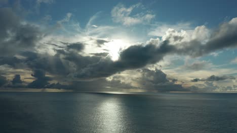 Impresionante-Paisaje-Del-Sol-Brillante-Detrás-De-Las-Nubes-Dramáticas-Sobre-El-Océano-Azul-Profundo-En-Una-Isla-En-Fiji---Plano-General