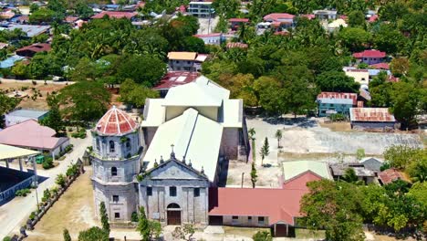 Fascinating-orbit-shot-of-old-spanish-church-seafront-of-the-beautiful-shore-view,-Our-Lady-of-Immaculate-Conception-Church-in-Oslob-Cebu,-Philippines