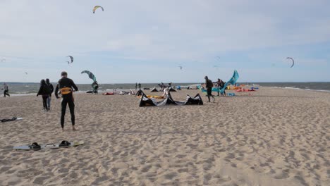 People-On-The-Shore-Preparing-Their-Power-Kites-For-Kiteboarding-In-Rewa,-Poland---wide-shot