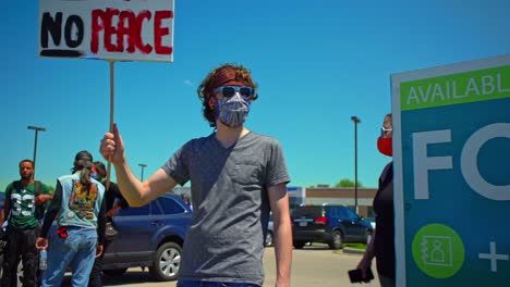 Janesville-Wisconsin-USA-slow-motion-of-a-caucasian-protester-holding-sign-no-justice-no-peace-black-lives-matter-protests-in-America-white-people-showing-solidarity