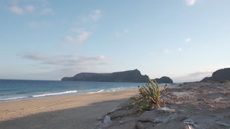 Panoramic-wide-shot-dunes-on-deserted-beach,-islet-background-Porto-Santo-Island