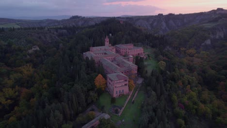 Medieval-red-brick-Benedictine-monastery-on-forest-hill-during-colorful-sunrise
