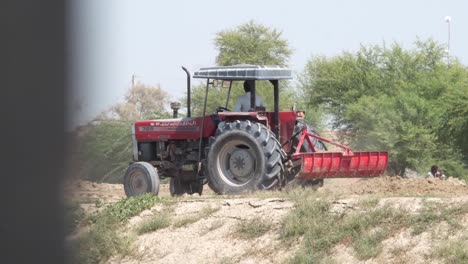 Roter-Traktor,-Der-An-Land-In-Punjab,-Pakistan-Umkehrt