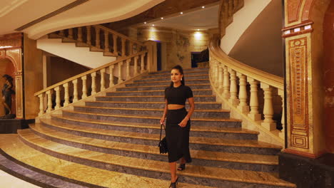 Young-Charming-Beautiful-and-Elegant-Brunette-Girl-Model-Walking-Down-Luxury-Interior-Stairs-and-Turning-Around,-Dressed-in-Black