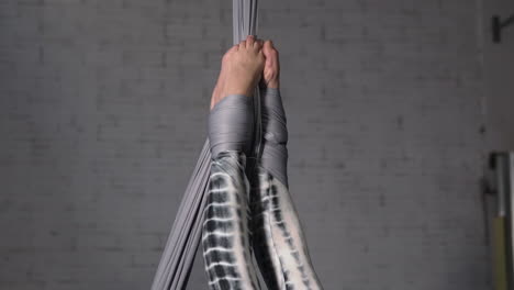Woman-hanging-from-her-feet-doing-acrobatic-silks-exericse
