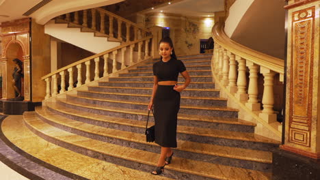 Young-Charming-Beautiful-Brunette-Lady-Model-Walking-Down-Luxury-Interior-Stairs-and-Turning-Around,-Dressed-in-Black