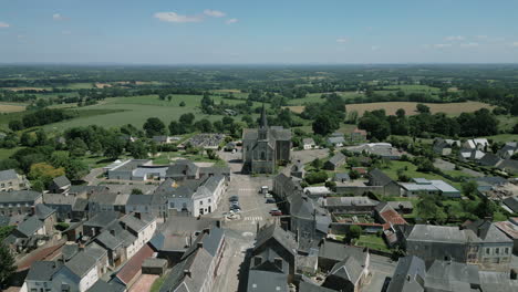 Saint-Corneille-and-Saint-Cyprien-church-in-La-Baconnière-municipality-and-countryside-in-background,-Mayenne-in-France