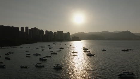Aerial-drone-shot-of-boats-floating-in-Hong-Kong-waters,-China