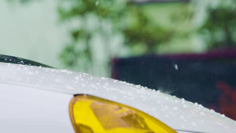 Hail-falls-onto-white-car-hood