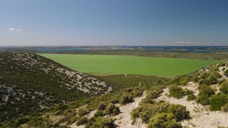 Scenic-aerial-view-of-drone-gliding-forwards-of-cryptodepression-waters-of-Naturpark-Vransko-Jezero,-Vrana-Lake-Nature-Park,-Croatia