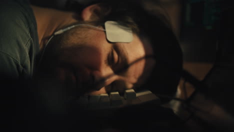 Man-rests-head-on-keyboard-then-opens-eyes-and-wakes-with-electrodes-on-his-head