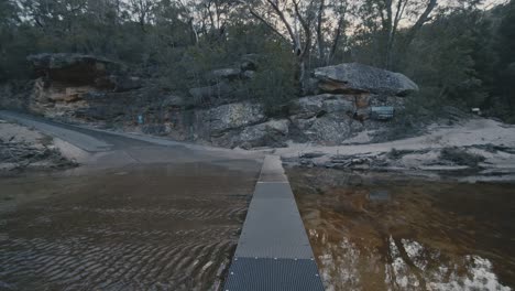 walking-along-bridge-across-water-at-Jellybean-pool-national-park-western-Sydney-Australia