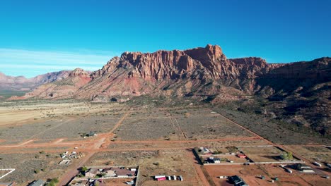 Red-Rock-Cliffs-above-Colorado-City,-Utah-town--Drone-zoom-in