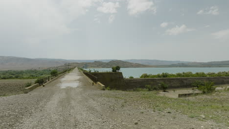 Bridge-and-asphalt-road-on-Dali-Mta-reservoir-dam-dyke-wall,-Georgia