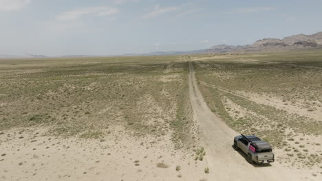 Jeep-driving-on-crude-dirt-road-trail-in-arid-steppe-plain-in-Georgia