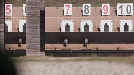 Bullets-hit-metal-target-in-shooting-range,-wide-shot,-static