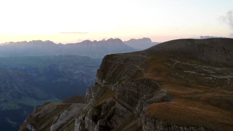 Luftaufnahme-Der-Felsen-Und-Berge-Von-Linthal-In-Glarus,-Schweiz-Während-Des-Sonnenuntergangs-Mit-Schwenk-Hinunter-Ins-Tal
