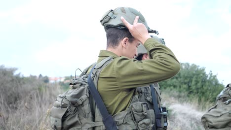 Israeli-brigade-soldier-put-on-helmet,-medium-shot-profile-view,-Golan-heights