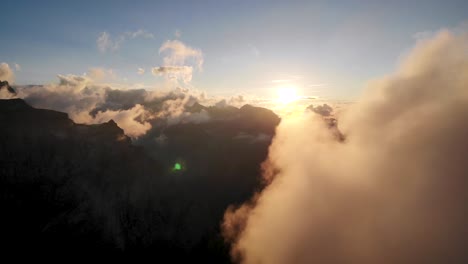 Flug-Zwischen-Glühenden-Wolken-Während-Eines-Sonnenuntergangs-In-Den-Schweizer-Alpen,-Während-Die-Sonne-Hinter-Wolken-Und-Berggipfeln-Verschwindet