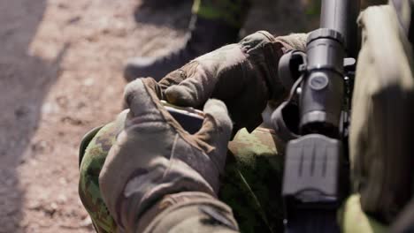 Soldier-hands-load-gun-magazine-with-bullets,-closeup,-handheld
