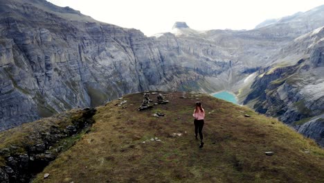 Un-Excursionista-Corriendo-Hacia-Un-Mirador-Sobre-El-Lago-Limernsee-En-Glarus,-Suiza,-Cuyas-Aguas-Color-Turquesa-Están-Rodeadas-De-Altos-Picos-Y-Acantilados-De-Los-Alpes-Suizos